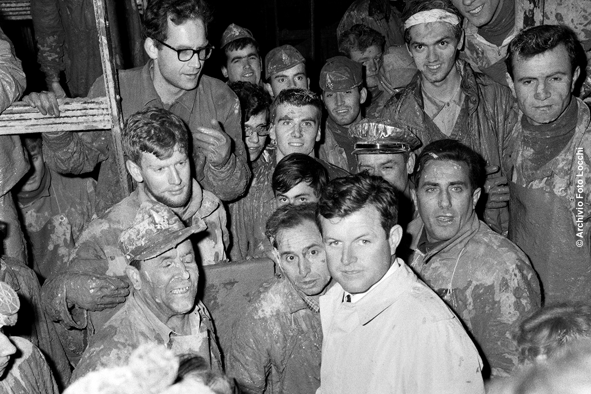 Ted Kennedy com um grupo de Ted Kennedy com um grupo de Mud Angels na Biblioteca Nacional de Mud Angels na Biblioteca Nacional de Florença, Biblioteca de Florença, que foi devastada por uma enchente em 4 de novembro de 1966. fl uvo 4 de novembro de 1966. Senador dos EUA, irmão do senador dos EUA, irmão do presidente JFK, tornou-se presidente JFK, tornou-se um símbolo deste importante para mover um símbolo criado, tornou-se um símbolo deste importante para um símbolo criado para um símbolo. 