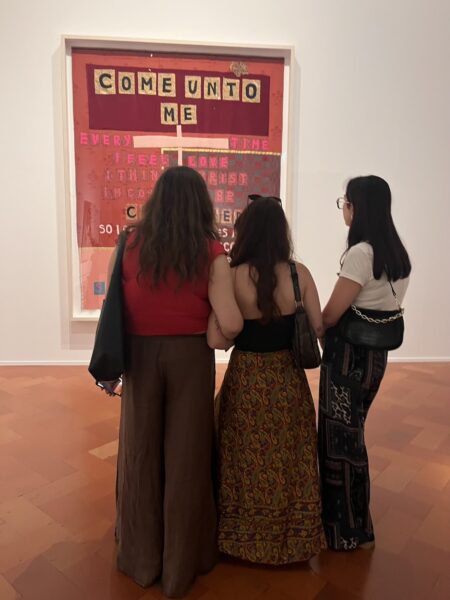 Group of friends observing and chatting about Tracey Emin’s piece of art